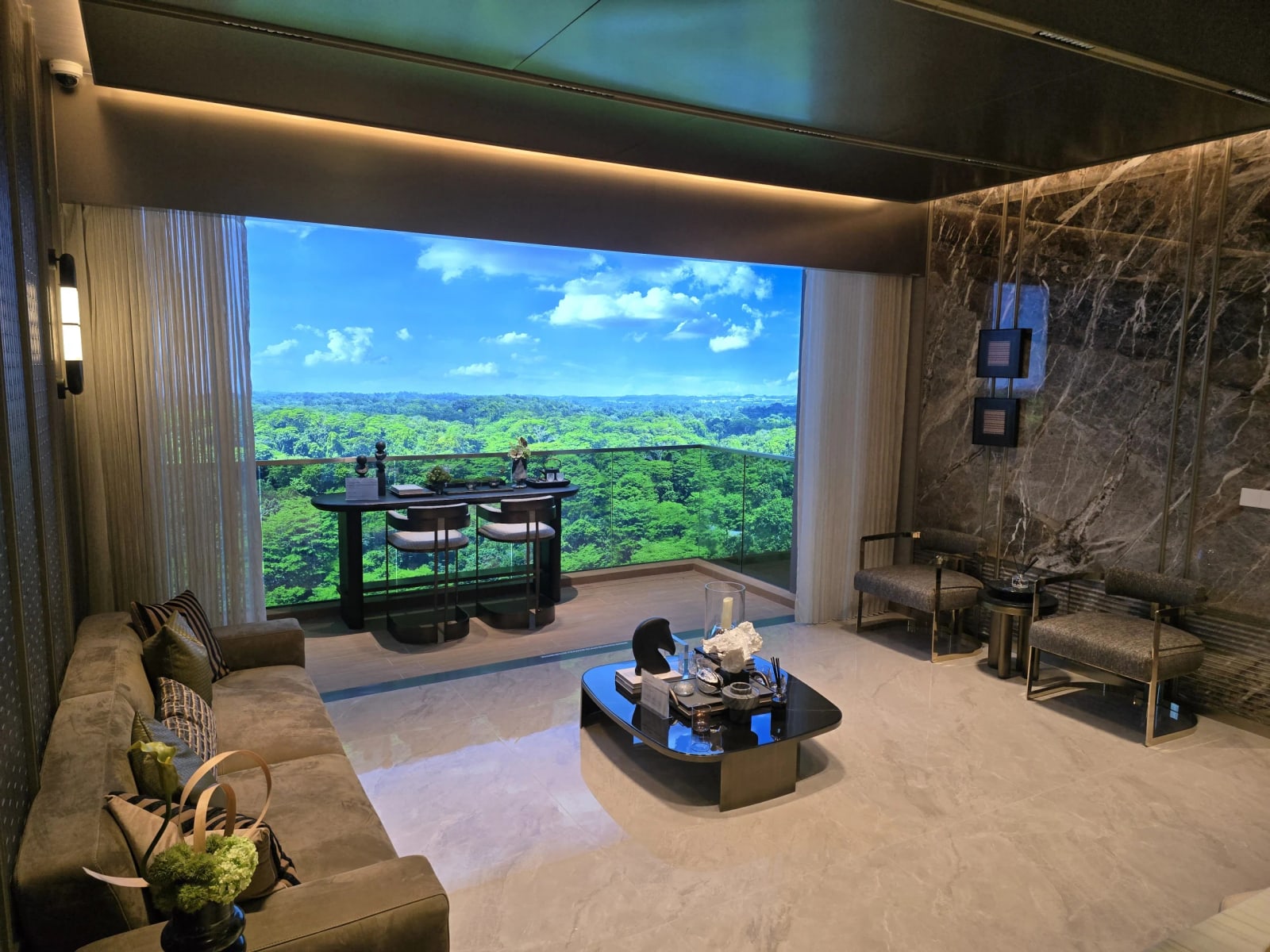 Photograph of the living room in the 4-bedroom show suite with a window wall and balcony