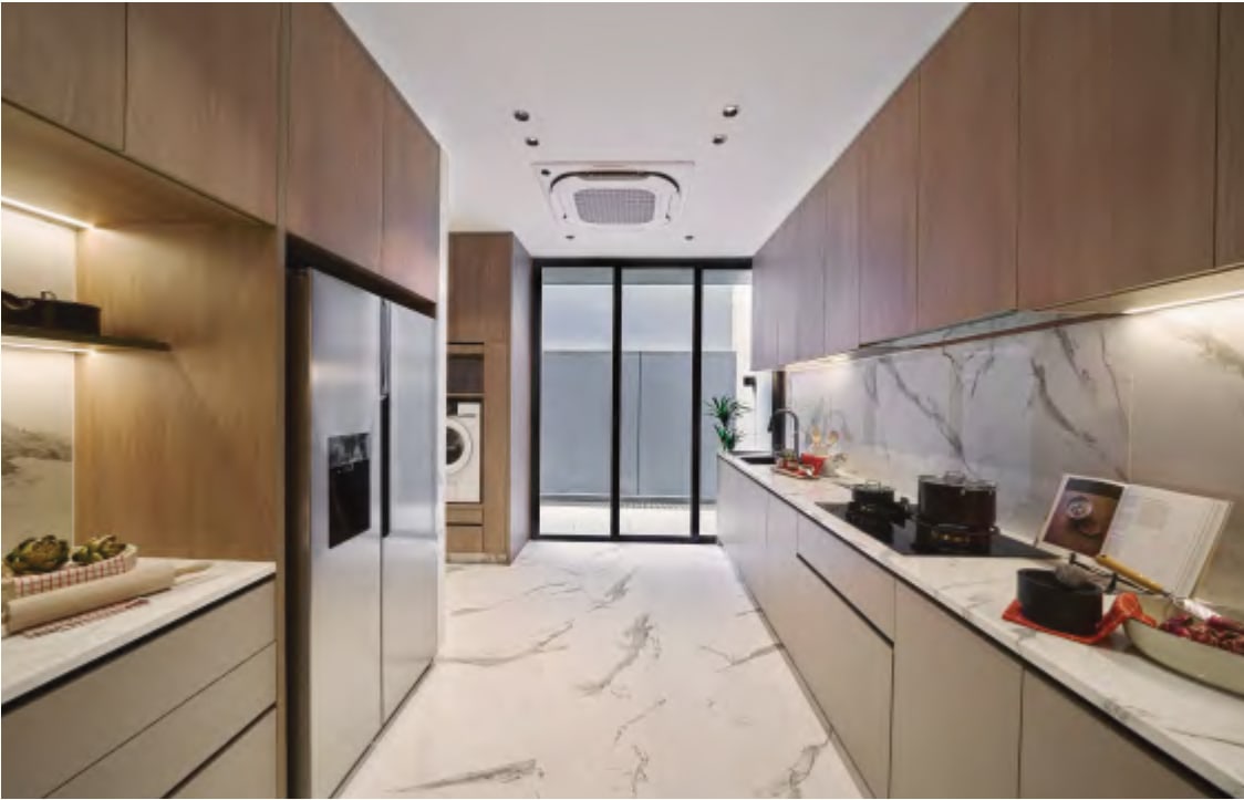 Interior picture of a long dry kitchen with a fridge, a marble backsplash and a glass door at the end