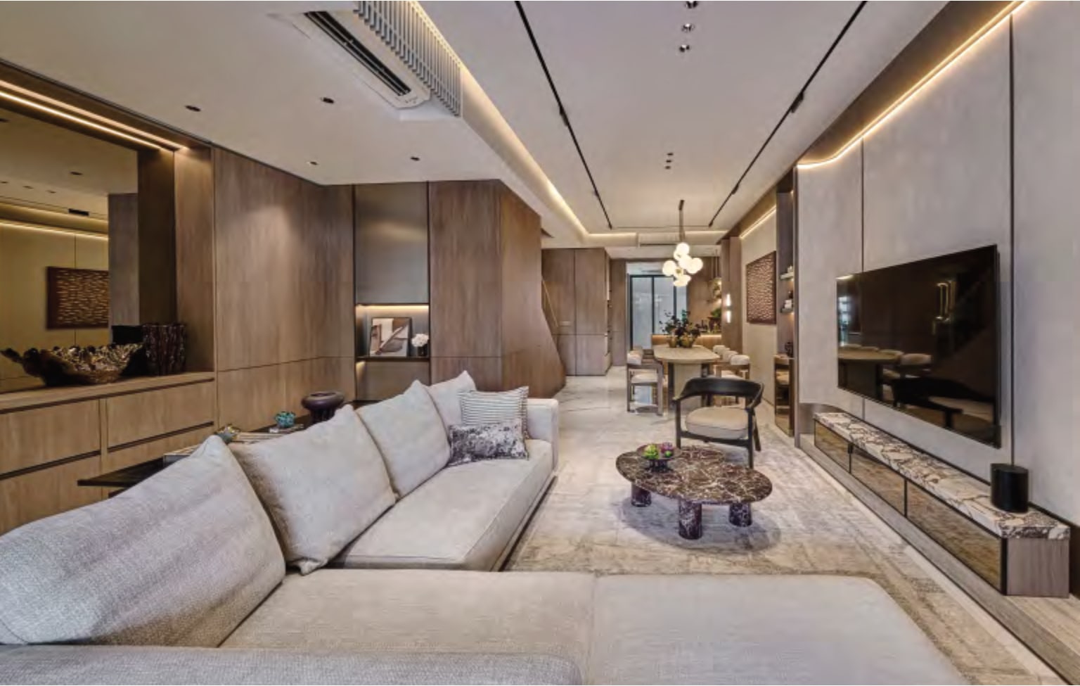 Interior picture of a living and dining area with a corner sofa, a television wall and a dining table beyond
