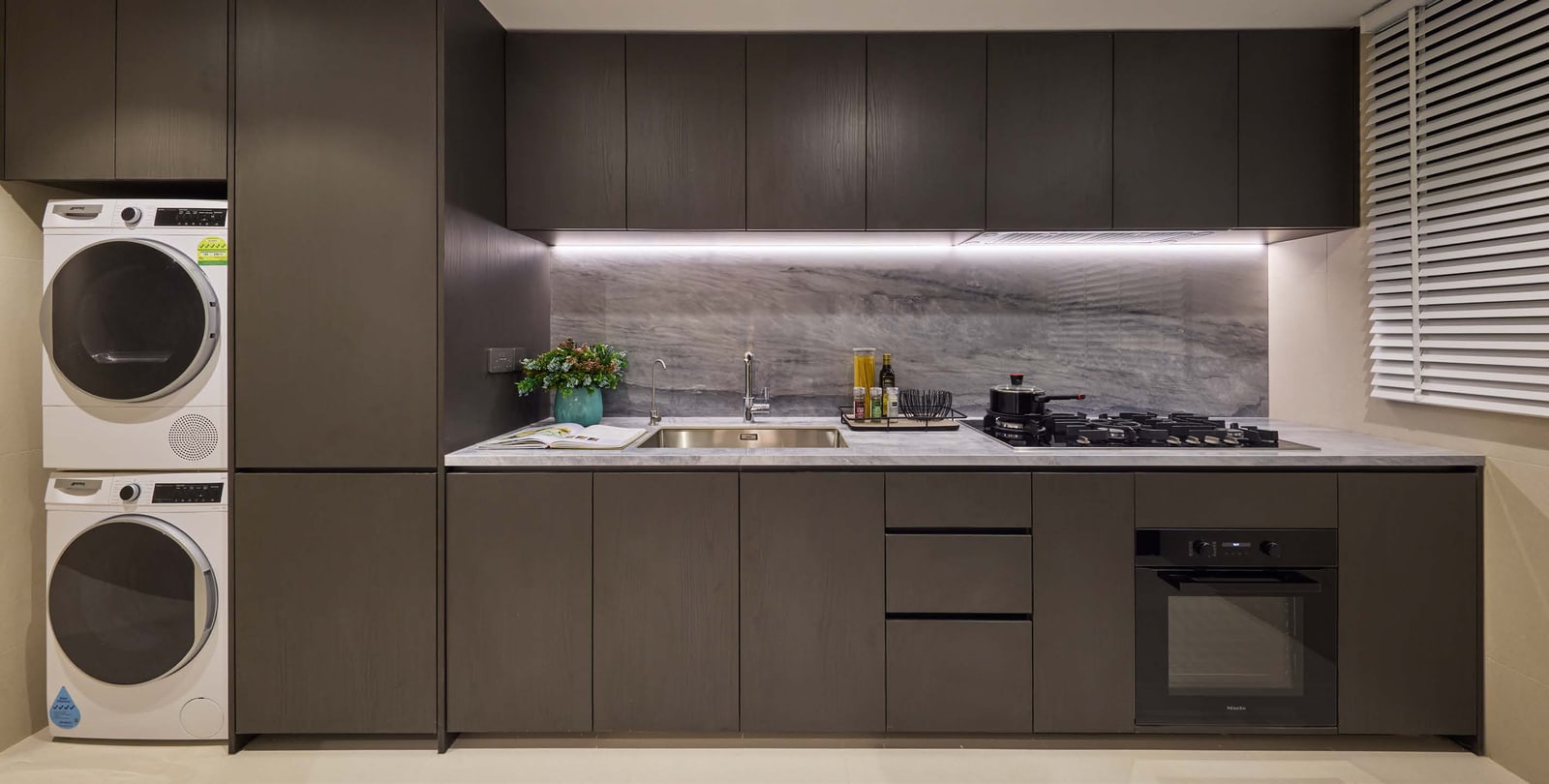 Illustration of a kitchen with dark cabinets and a stacked washer and dryer
